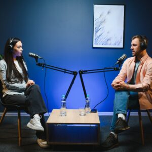 Show host interviewing woman during live stream, talking about fashion and style trends