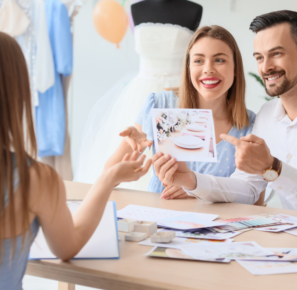 vnv events: Young Couple with Pictures Planning Their Wedding in Office