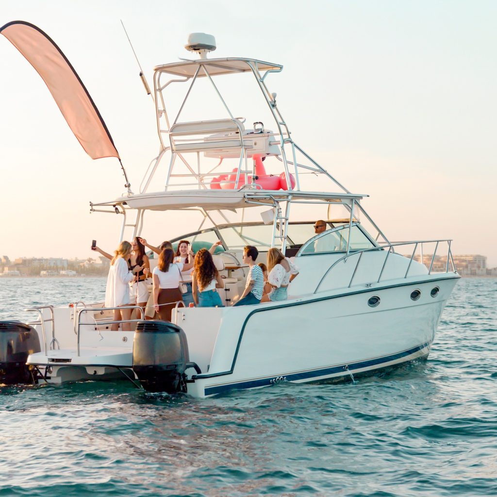 vnv events: Event planner services in Miami- Budget Bachelorette Party Ideas -2 - Cheerful young females in bathrobes celebrating bachelorette party -Youth party on vacation at sea. Girlfriends drink champagne, dance on the yacht